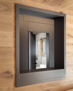 Piccola finestra interna all'appartamento realizzata in falegnameria, con finitura laccata opaco colore grigio. Dalla finestra si intravvede la porta aperta sul bagno.