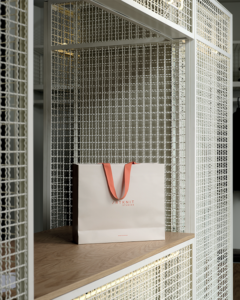 Bancone vendita in rovere e griglie metalliche verniciate. Sacchetto Artknit Studios 